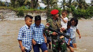 Photo of Aksi Mulia,Membantu Seorang Ibu Yang Membawa Anak Kecil Menyeberangi Sungai